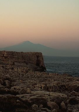 Volcano Overlooking Rocky Coastline at Sunset