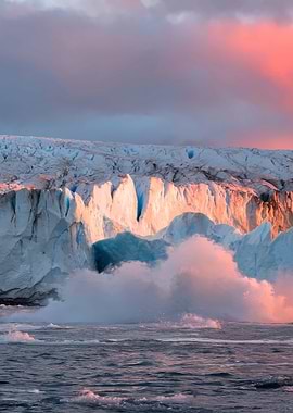 Glacier calving into the ocean at sunset