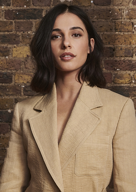 Naomi Scott in a beige blazer