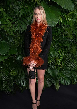 Margot Robbie in a black dress with feather trim