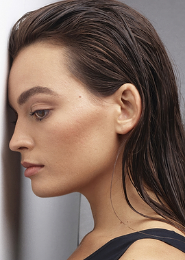 emma mackey with wet hair leaning against wall