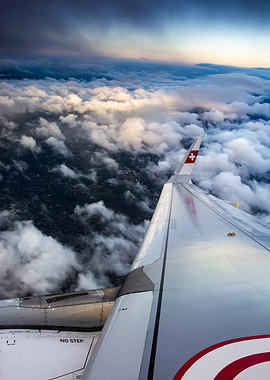 A321 Airplane wing over clouds at sunset
