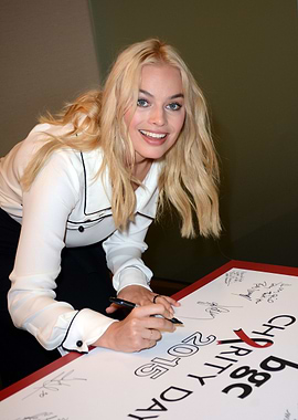 Margot Robbie signing a charity poster