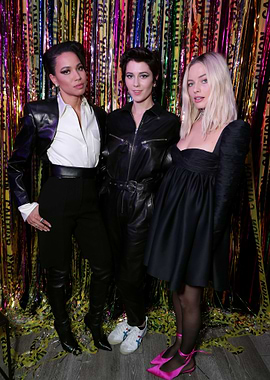 Three women posing in stylish outfits