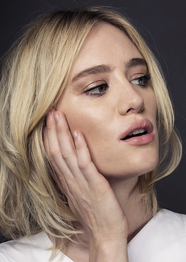 Mackenzie Davis with blonde hair touching her face