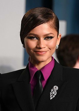 Zendaya in a black suit with pink shirt