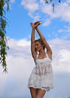 Woman in white dress against blue sky