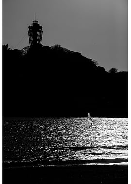 Windsurfer silhouetted against sunlit sea