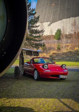 Red Mazda Miata by Cooling Tower