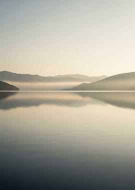 Misty Mountains Reflected in Calm Lake