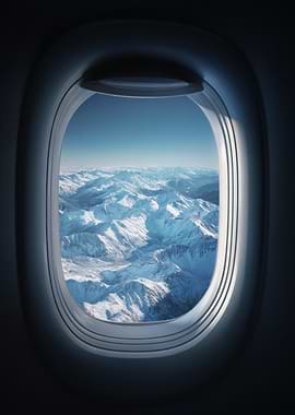 Airplane Window View of Snowy Mountains