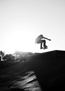 Skateboarder jumping against the sun