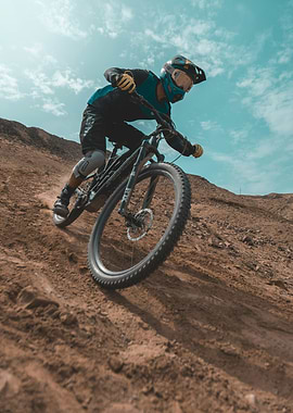 Mountain biker descending a dusty slope