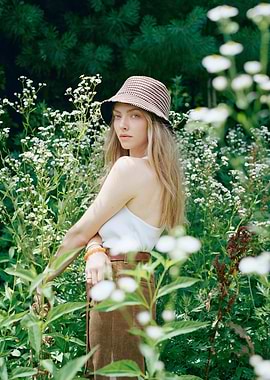 Woman in bucket hat among flowers
