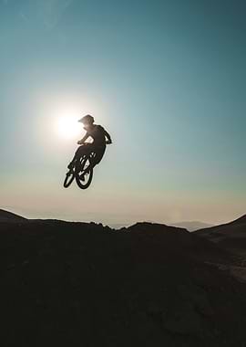 Mountain biker jumping against the sun