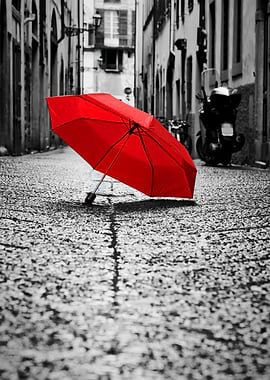 Red umbrella on a cobblestone street