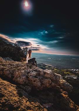 Woman on rocky outcrop overlooking landscape