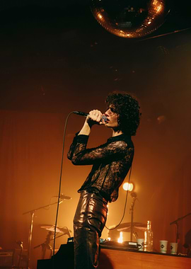 Sombr performing on stage with disco ball
