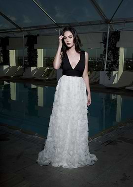 Woman in a black and white gown by a pool