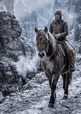 Woman riding a horse in a snowy canyon