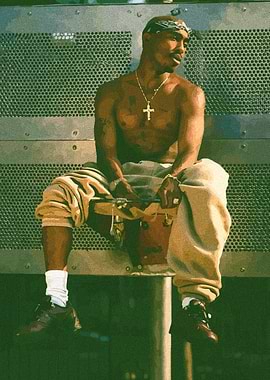 Tupac Shakur sitting outdoors