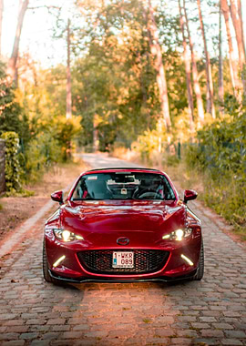 Red Mazda MX-5 on Cobblestone Road