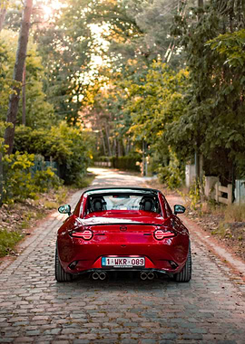 Red Mazda MX-5 on Cobblestone Road