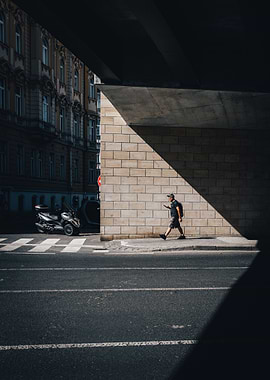 Man walking under bridge in city