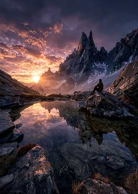 Man overlooking a mountain lake at sunset