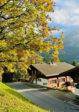 Autumn scene with Swiss chalet and mountains