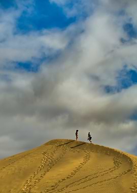 Two people on a sand dune