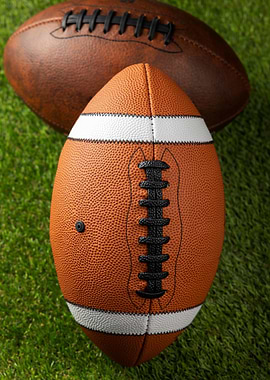Two American Footballs on Grass
