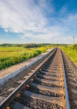 Railway tracks curving through a green landscape