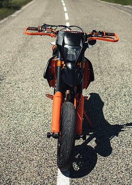Orange and black supermoto motorcycle on road