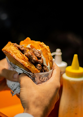 Person holding a loaded burger