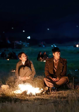 Couple by campfire at night