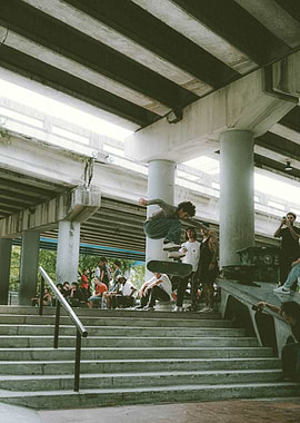 Skateboarder mid-air jump under bridge