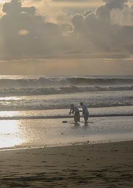 Two people on a beach at sunset