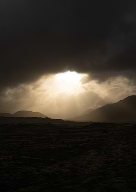 Dramatic Sunbeams Through Stormy Clouds Over Mountains