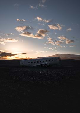 Crashed plane on a Black Sand Beach at Sunset