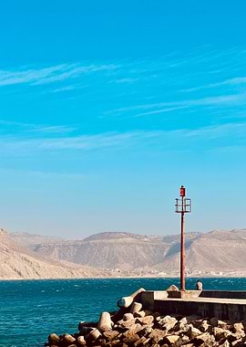 Coastal landscape with lighthouse and mountains