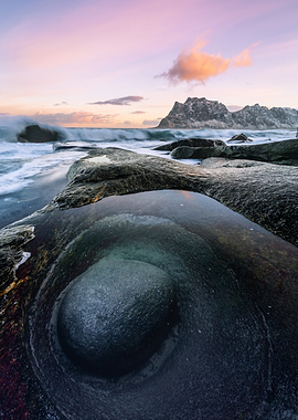 Ocean waves crashing on rocky shore at sunset