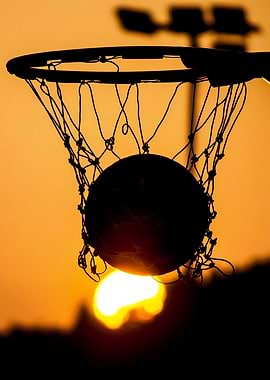 Basketball going through hoop at sunset