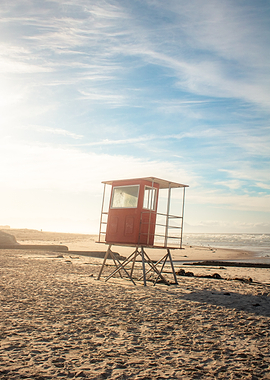Red lifeguard tower on a sandy beach