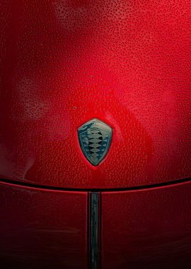 Red Koenigsegg car hood with water droplets