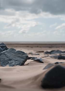 Dark Rocks on Sandy Beach