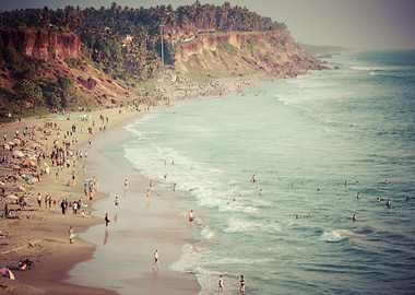 Sunbathers and swimmers gather on the beach below the c ...