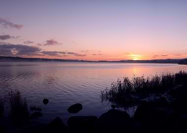low fog hangs over the loch as the sun slowly sets