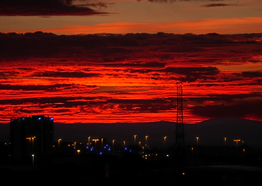 A plane takes off against a striking red sunset