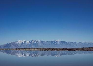 The Wasatch Mountains reflected in the still waters of ...